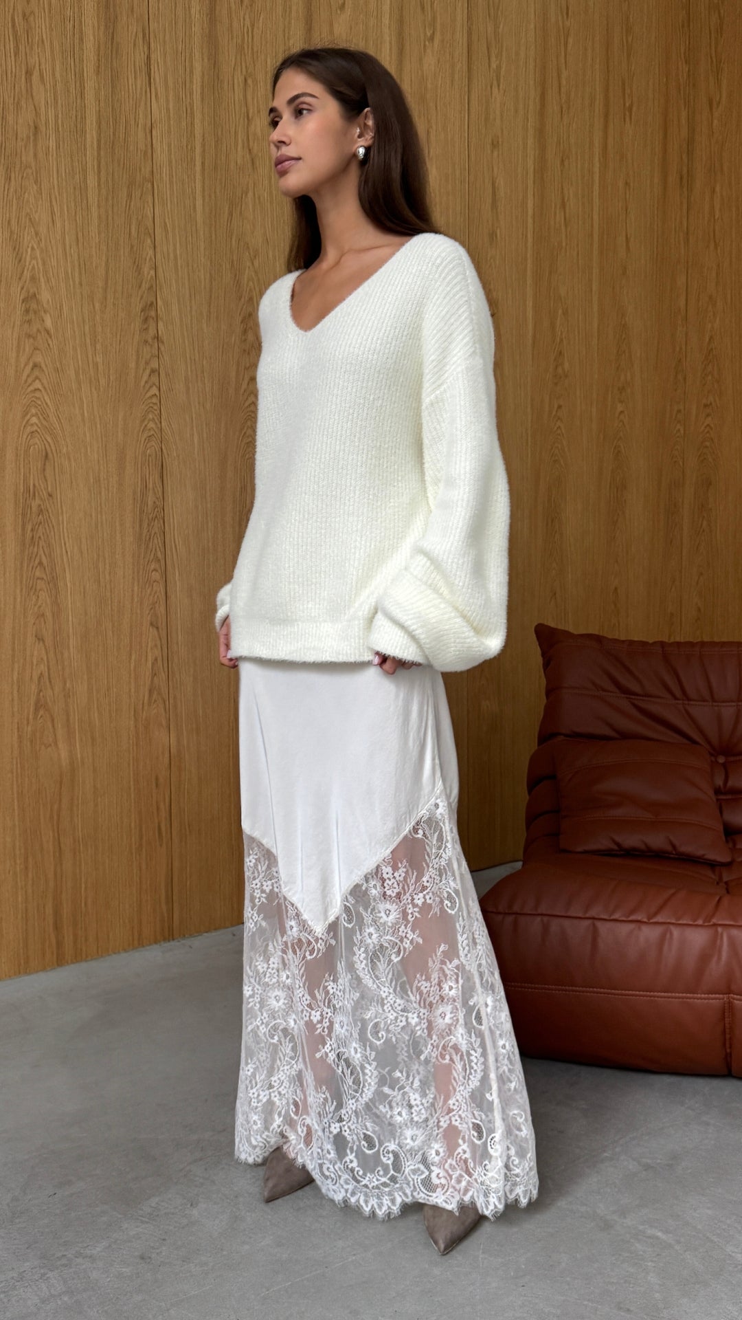 Front view of the Moonbeam skirt styled with a cream V-neck knit, showing its flowing shape and lace-trimmed hem.