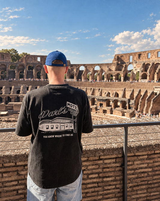 dDARL Motel Tee in Washed Black, worn from behind at the Colosseum in Rome