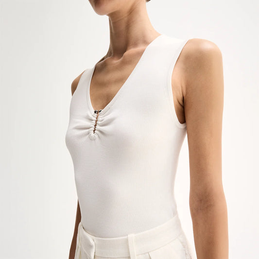 A close-up shows the fitted white sleeveless top with a V-neckline and ruched centre front.