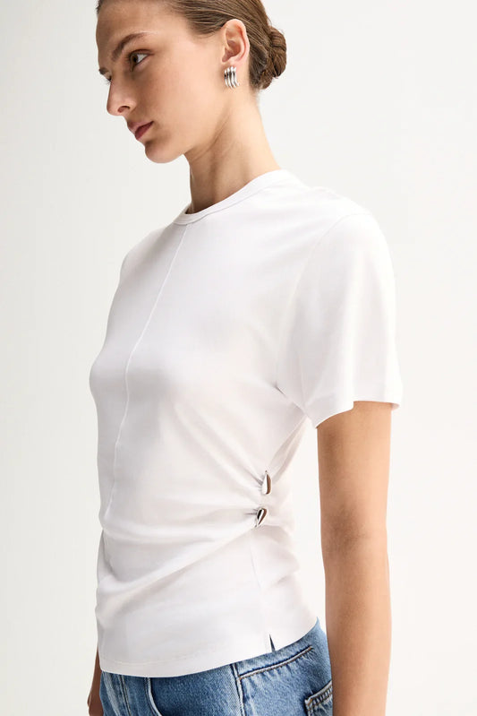 A close-up shows the white short-sleeve top with a crew neckline, centre seam and silver ring details at the side waist.