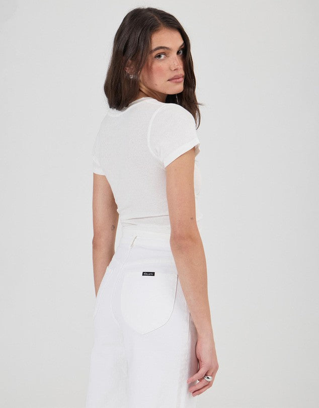 Rear three-quarter view of vintage white jeans showing the high-rise waistband, curved back pockets, belt loops and wide leg.