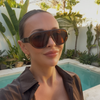 A woman wearing the Whiskey sunglasses in a close-up outdoor setting beside a swimming pool.