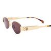 Close angled view of the 180EYEWEAR 'Isla' sunglasses in gold with brown lenses, showing the gold hinge hardware and oval lens shape.