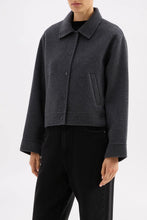 Person wearing a dark gray jacket on a white background