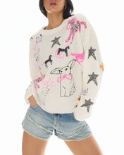 Person wearing a cream-colored sweater with dog illustrations on a white background