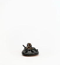 A single black leather baby mule shoe with a gathered, ruched design and a small bow detail on the side, photographed against a seamless white background.