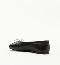 Black leather flat shoe on a white background