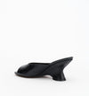 Rear side view of the black leather mule showing the open-back design and sculptural wedge heel.