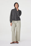 A model wears the Arcaa Addie Jacket in charcoal with light wide-leg trousers in a full-length front studio view.
