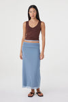 Front view of the espresso side of the reversible sleeveless top with a V-neckline, styled with the pale blue maxi skirt and black sandals against a white studio background.