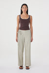 Model wearing the espresso tank with cream tailored trousers, showing the square scoop neckline, wide straps, contrast cream trim and close-fitting shape in a full-length front view.