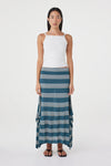 Full-length front view of the teal striped maxi skirt styled with a white sleeveless top and black sandals against a clean white studio background.