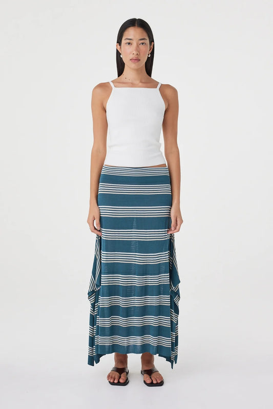 Full-length front view of the teal striped maxi skirt styled with a white sleeveless top and black sandals against a clean white studio background.