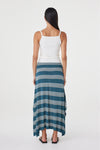 Back view of the teal striped maxi skirt showing the flowing asymmetric hem, styled with a white sleeveless top and black sandals in a clean white studio.