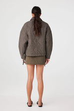 Person wearing a plaid jacket and skirt on a white background