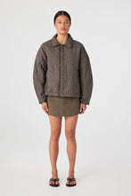 Person wearing a plaid jacket and green skirt on a white background