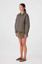 Person wearing a checkered shirt and shorts on a white background