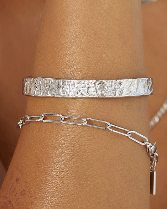 Arms Of Eve Olivia Silver Cuff Bracelet styled on the wrist with a silver chain bracelet.