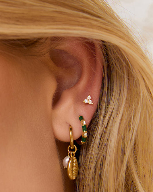 Arms Of Eve Papaya Enamel Huggies Kiwi styled in a layered gold earring stack.