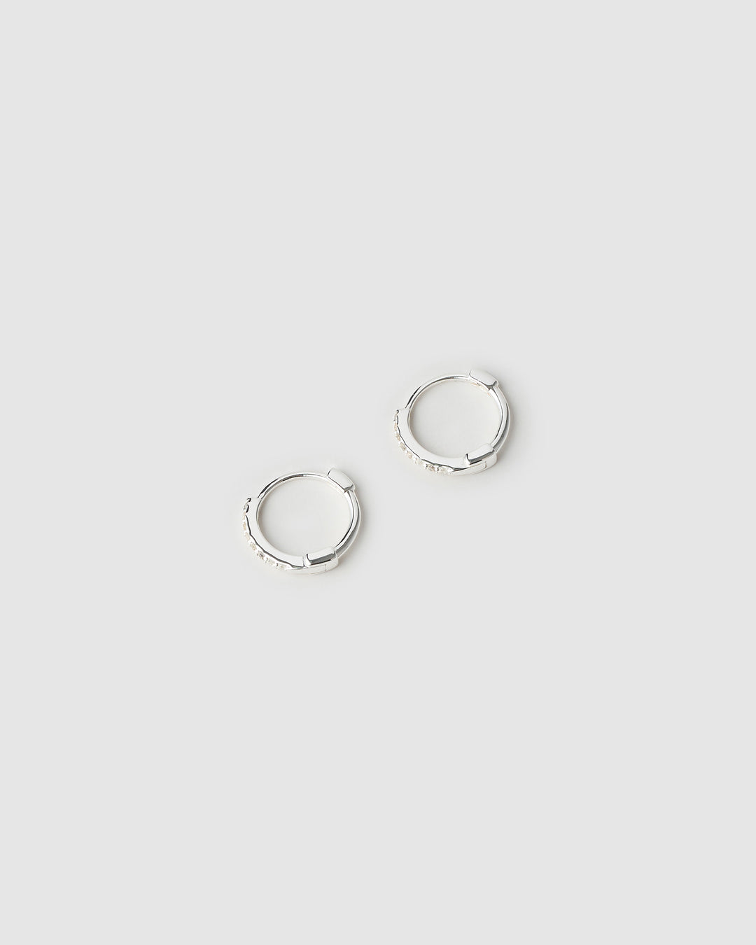 Two silver hoop earrings on a light gray background