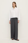 Front view of a white cropped shirt with a pointed collar, button closure and relaxed boxy silhouette.