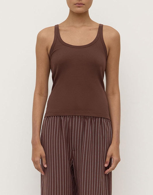 Model wearing the espresso rib tank with striped relaxed trousers, showing the scoop neckline, wide shoulder straps, fitted silhouette and hip-length hem, front view
