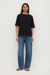 Front view of the black tee showing its relaxed boxy shape, short sleeves and ribbed neckline.