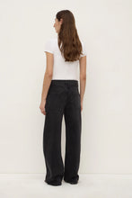 Person wearing black wide-leg pants and a white top on a white background