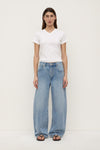 A model wearing indigo fade mid-rise relaxed jeans with wide legs, five-pocket construction and curved outer seams that taper towards the hems, shown from the front.