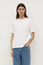 Model wearing the white Organic Base Tee with relaxed blue jeans, showing the crew neckline, short sleeves, straight hem and easy relaxed fit, front view
