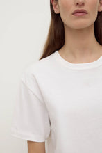 Close-up of the white tee, showing the classic crew neckline, short sleeves, smooth cotton jersey and clean minimal finish, front detail view
