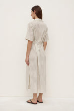 Model wearing the striped midi shirt dress, showing the back collar, short sleeves, waist tie and straight midi-length silhouette, back angled view
