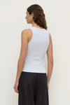 Model wearing a powder blue fitted rib tank with black trousers, showing the sleeveless cut and fitted back, back view