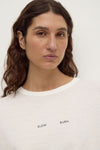 Assembly Label Slow Burn Wide Sleeve Tee in Antique White, close-up showing the ribbed neckline and Slow Burn graphic.
