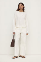 Assembly Label Slow Burn Wide Sleeve Tee in Antique White, full-length front view styled with white trousers and a brown bag.
