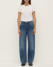 Model wearing the white Zali Short Sleeve Tee with relaxed blue jeans and black flats, showing the crew neckline, fitted short sleeves and close-to-body silhouette, full-length front view
