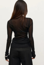 Person wearing a black long-sleeve top and pants on a white background