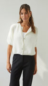Front view of the ivory cardigan showing its relaxed fit, short sleeves, round neckline and pearl-style buttons.