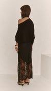 A back three-quarter view of the black lace skirt, highlighting the flowing silhouette and sheer lace hem.