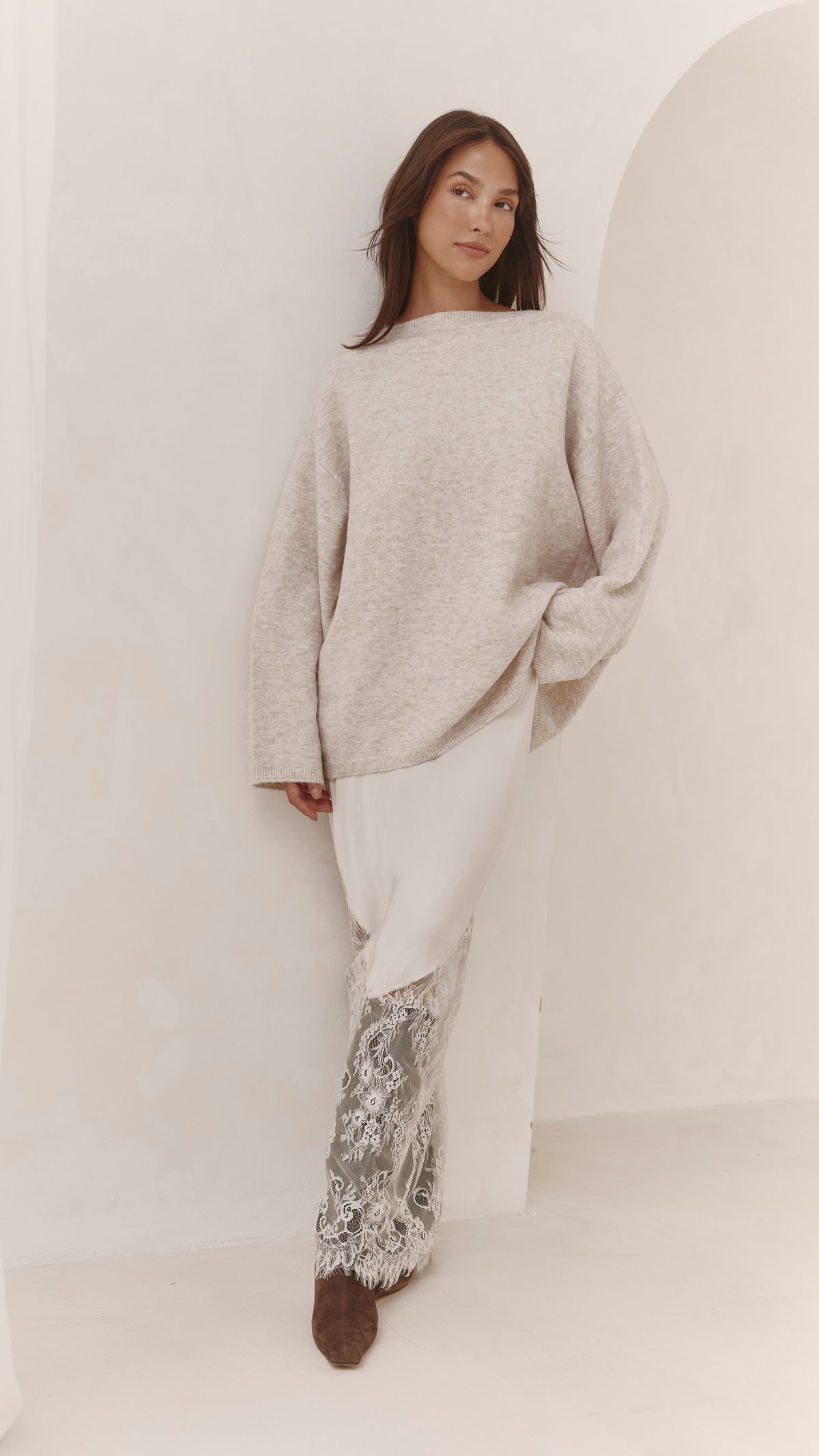 A model wearing the Moonbeam skirt with a neutral oversized knit, showing the flowing silhouette and lace detailing.