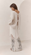 Back view of the Moonbeam skirt worn with a loose knit top, showing the skirt's draped shape and lace-trimmed hem.