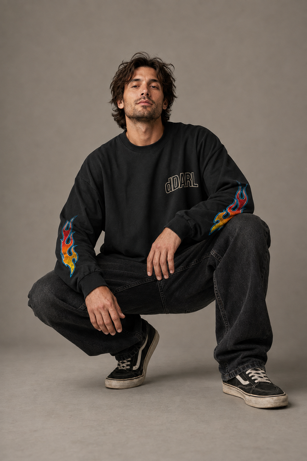 dDARL Flame LS Tee in Black, worn by a man crouching, showing the flame sleeves
