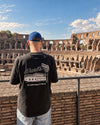 dDARL Motel Tee in Washed Black, worn from behind at the Colosseum in Rome