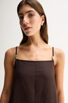 Close-up of the chocolate dress showing the straight neckline, thin adjustable straps and silver hardware details.