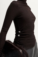 Black ribbed sweater with silver buttons on a white background