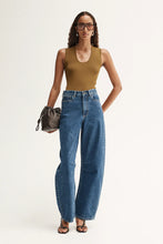 Model wearing the moss Hayes Knit with blue wide-leg jeans and black sandals, showing the fitted silhouette, scoop neckline and ribbed knit texture, full-length front view
