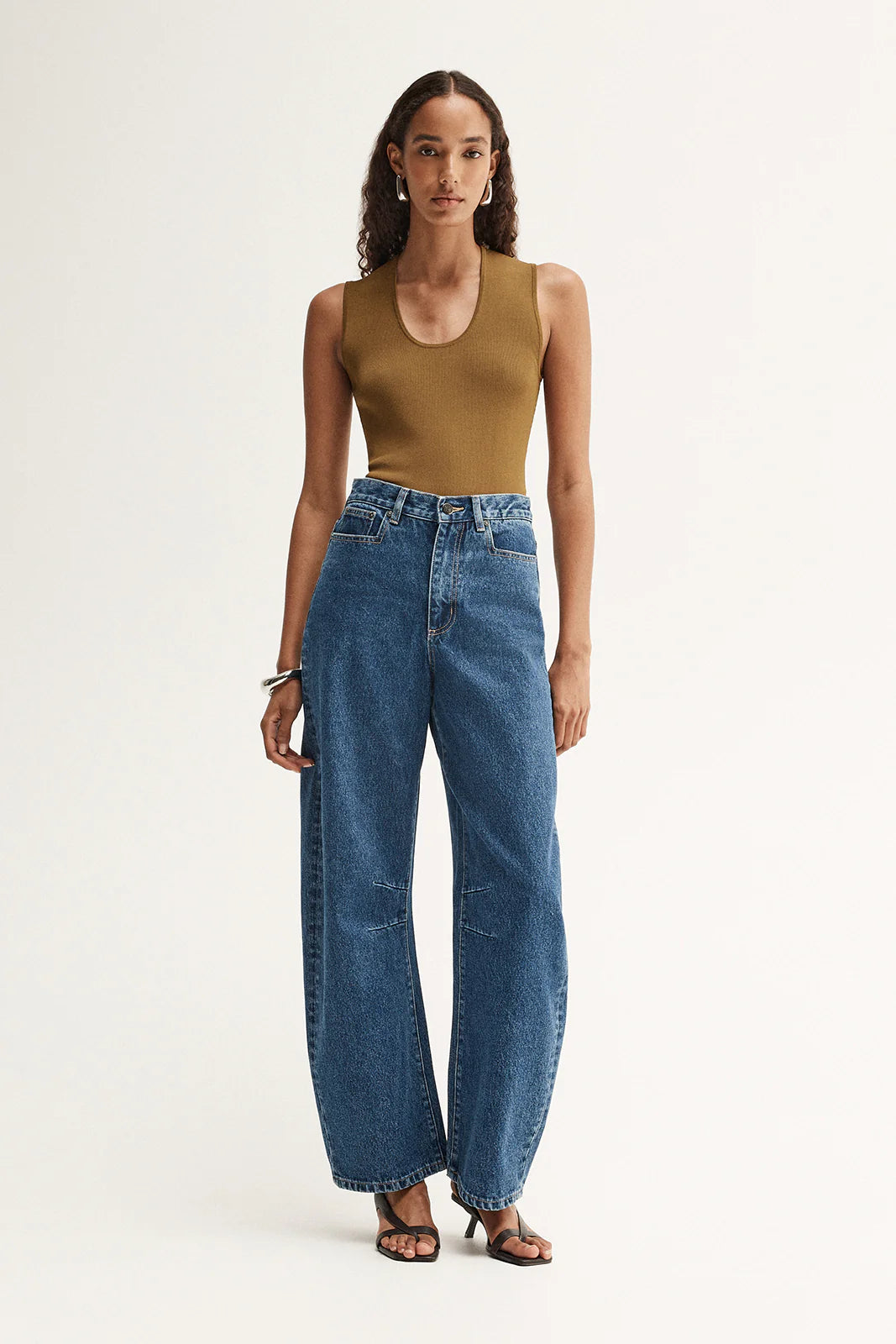 Model wearing the moss Hayes Knit with blue wide-leg jeans and sandals, showing the fitted shape, scoop neckline and ribbed texture, full-length front view