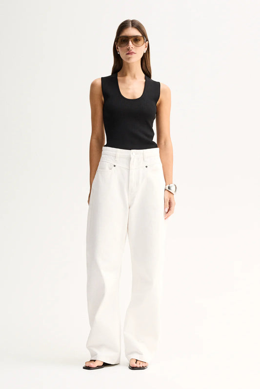 A model wears the Elka Collective Hayes Knit Top in Black with white wide-leg trousers in a full-length front view.