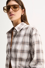 A model wears the White Check shirt in a close-up front view showing its pointed collar, button placket and check pattern.