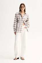A model wears the White Check shirt with white wide-leg trousers in a full-length front view.